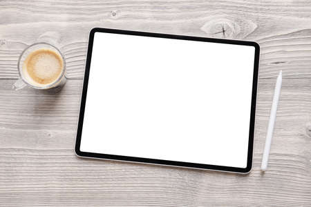 Tablet mockup with empty white screen and wireless stylus pen on tableの写真素材