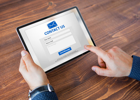 Man submitting contact form on websiteの写真素材