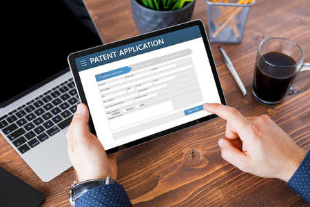 Man submitting patent application onlineの写真素材