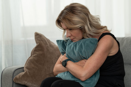 Sad woman sitting lonely on couch