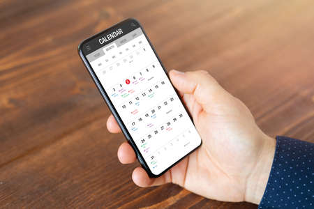 Man using calendar app on mobile phoneの写真素材