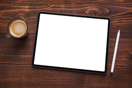 Cup of coffee next to tablet computer with blank white screen and wireless stylus pen for drawing and writing on the screen.の写真素材