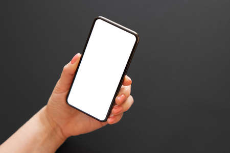 Person holding phone in hand on dark backgroundの写真素材