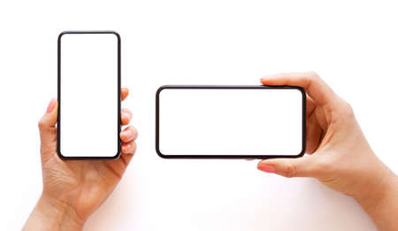 Mobile phone with empty white screen in hand in horizontal and vertical orientation, isolated on white backgroundの写真素材
