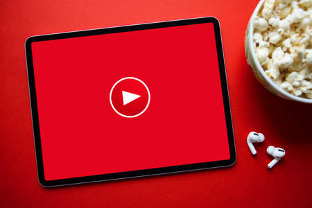 Red video play icon on the screen of tablet, concept of watching online videosの写真素材