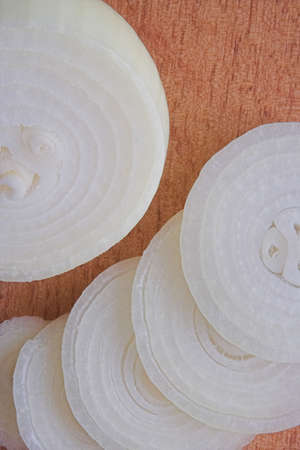 White rings of  onion cut on the wooden board took closeの写真素材
