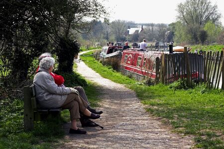 A retired couple sitting by a canal.の写真素材