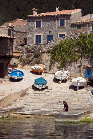 Fishing village with boats and slipway viewed from across the habourの写真素材