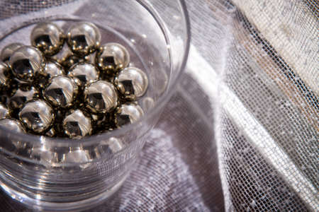 Chrome spheres in clear glass next to the window.の写真素材