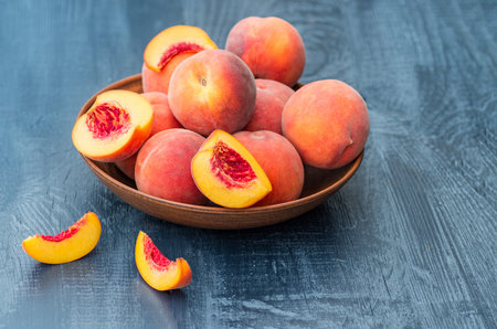 Ripe peaches in a wooden bowl. Rustic background. Free space for text.の写真素材
