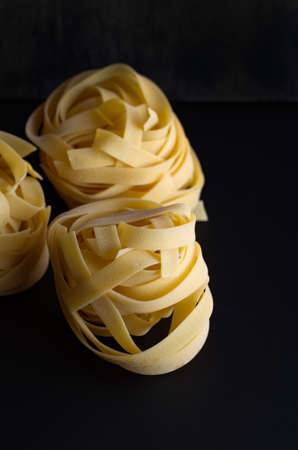 Fettuccine macaroni classic on a black background. Basis for dishes of Italian cuisine.の写真素材