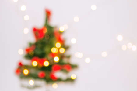 Blurred background. Christmas tree on a white background. Garland on the wall. Christmas tree in a white room for Christmas.の写真素材