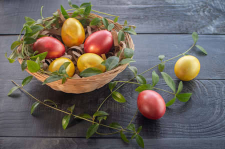 Easter eggs in a wicker basket on a wooden background. Happy Easter.の写真素材