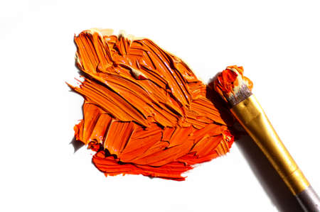 Orange oil paint and brush on white backgroundの写真素材