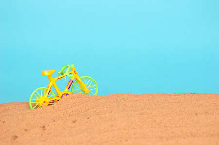 sandy beach by the sea. The concept of summer holidays and tourism. Toy bike on the beach. minimalismの写真素材