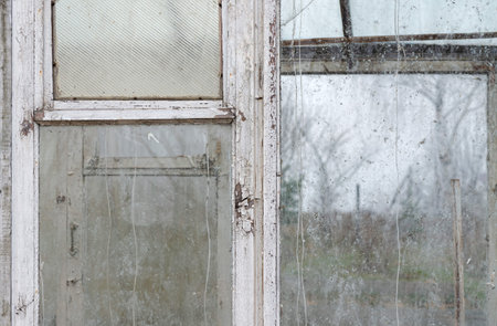 Old wooden window frame with dirty glass. Close up.