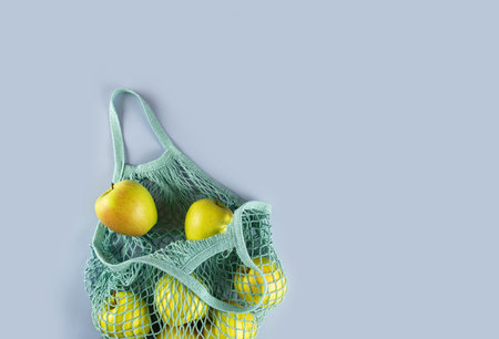 Bag with apples on a gray background. Ecological concept. Flat lay.