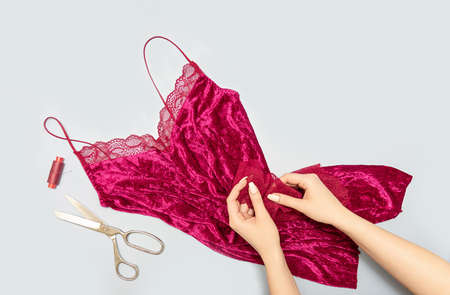 The process of manually sewing linen. Scissors, accessories for sewing. Lace in the hands of a tailor close-up. The apartment was lying. Copy spaceの写真素材