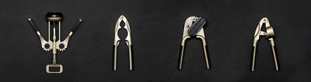 A set of kitchen utensils on a black background, garlic press, wine corkscrew for bottles,...