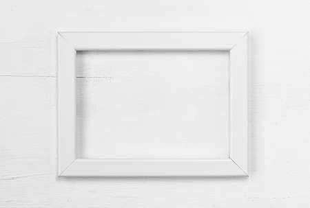 White frame on a white wooden background. Top view. Copy space. Flat lay. Minimal concept.の写真素材