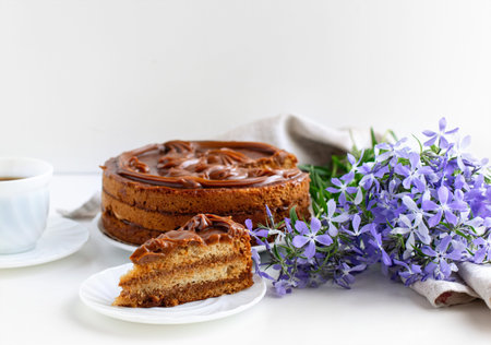 Homemade honey cake decorated with caramel on a light background. Home baking concept. Close up.
