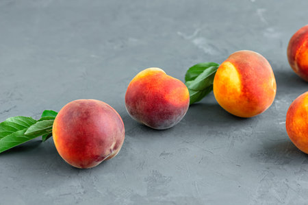 Fresh peaches on a stone gray background, food and harvest concept. Breakfast, healthy raw vegan...