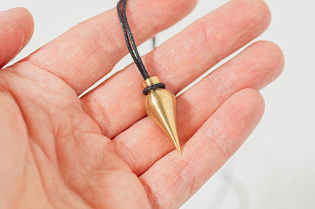 Brass pendulum for dowsing and energy work held in hand. Used in holistic healing, spiritual...