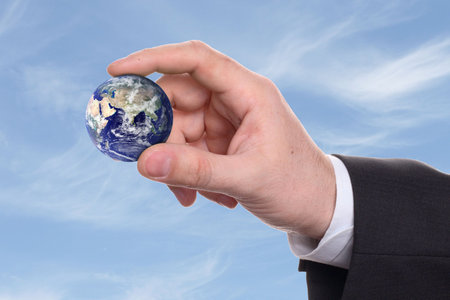 small earth in a hand on background blue sky