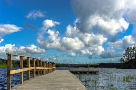 Berth. Blue sky in the summer. Pier in sunny weather. Clouds fly over the pierの写真素材