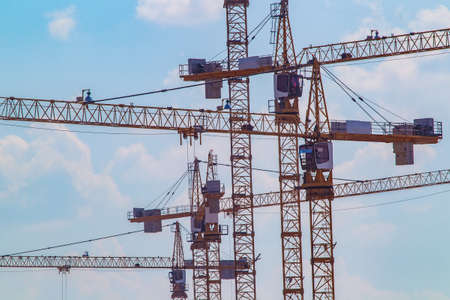 Construction cranes. Construction. Many building cranes against the sky.の写真素材