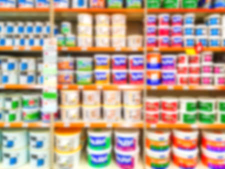 Blurred background. Shelves with goods. Sale of paint for repair. Sale of chemistry. Score. Hypermarket Paint in cans on store shelves.の写真素材