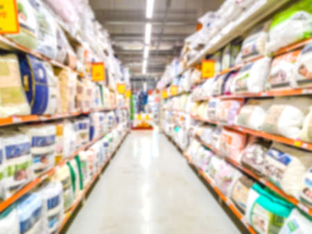 Blurred background. Shelves with goods. Household products. goods for bedroom. Sale of pillows. Score. Hypermarket Linens. Odyala and pillows on the shelves of the store.の写真素材
