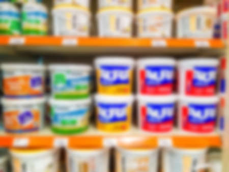 Blurred background. Shelves with goods. Sale of paint for repair. Sale of chemistry. Score. Hypermarket Paint in cans on store shelves.の写真素材