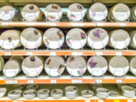 Blurred background. Shelves with goods. Household products. goods for the kitchen. Sale of plates. Score. Hypermarket Dishes White dishes on the shelves.の写真素材