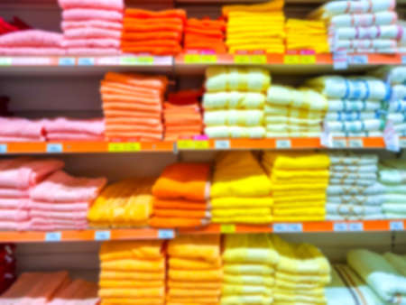 Blurred background. Shelves in the Hypermarket. Towels are on the shelves of the store. Colored towels.の写真素材