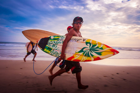 Ecuador. The village of Montanita. Surfers with surfboards run to the beach. Serfengists on the shore of a quiet ocean in Ecuador. 05/04/2006のeditorial素材