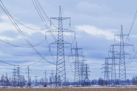 Electric towers with wires. Electric high voltage tower with electric line against clear blue sky.の写真素材