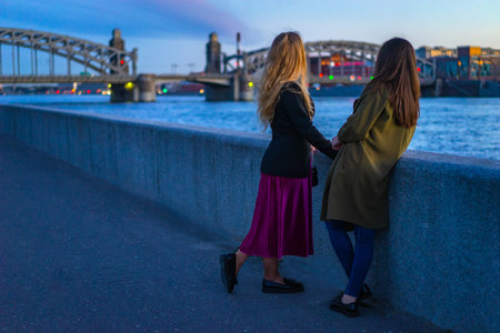 Petersburg. Girls are looking at the Bolsheokhtinsky Bridge. The neva river in St. Petersburg. The Bridge of Peter the Great. Journey through Petersburg. 09/05/2018のeditorial素材