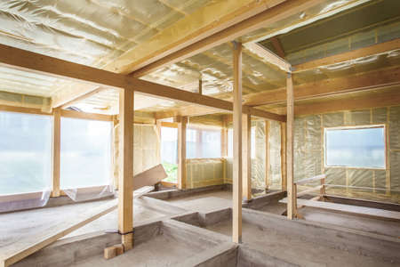 Warming of the walls of the house. Home construction. Construction works. The walls are covered with film. Steam insulation of house walls.の写真素材