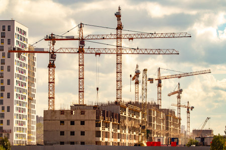 Construction of multi-storey houses. Construction cranes. Construction site.