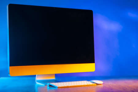 Large monitor. The monitor from the computer is on the table. A place for an inscription on the computer monitor. Computer on a blue background.の写真素材
