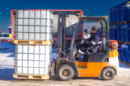 Blurred loader. Loading barrels with chemistry. Chemical production. Plastic barrel for chemistry....