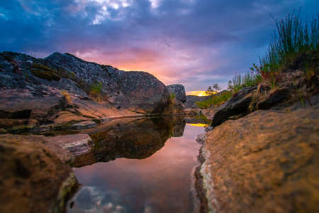 Sunset. The sun hid behind a rock. Reflection of the sky in the water. Karelia. Rocks of Karelia. Nature of Russia.の写真素材