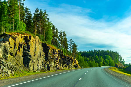 Road. Empty highway. Rocks on the side of the road. The road to Karelia. Roads in Russia. Road through the rocks.の写真素材