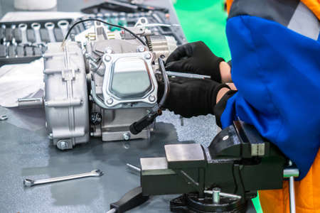 Engine repair. motor service. Mechanic disassembles the motor. Workbench with a vice. Man at work. Locksmith in the workshop.の写真素材