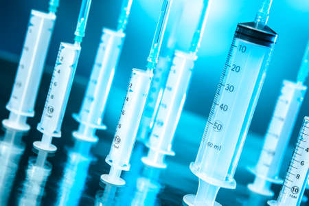 Syringes on a turquoise background. Medical syringes. Vaccination. Vaccinations. Use of vaccines. Doing medical protarators. Medical laboratory.の写真素材
