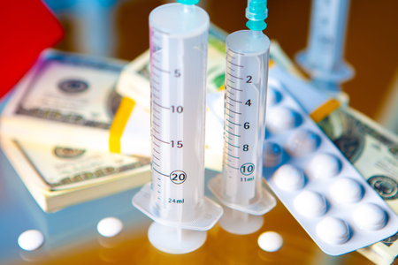 A bundle of money against the background of syringes. Paid medicine. Medical insurance. Expensive...