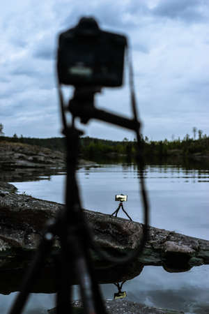 Photo session on the lake. Photo equipment on tripods on a natural background. Shooting the natural landscape.の写真素材