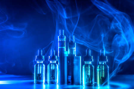 Smoke from electronic cigarettes. Liquids for VAPE. Replacement of tobacco. Fashionable devices for smoking electronic cigarettes. VAPE liquid bottlesの写真素材