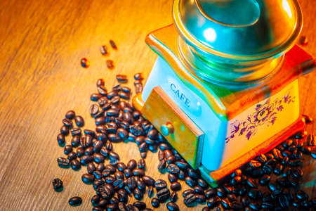 Coffee beans. Coffee is scattered on the table. Coffee grinder.の写真素材